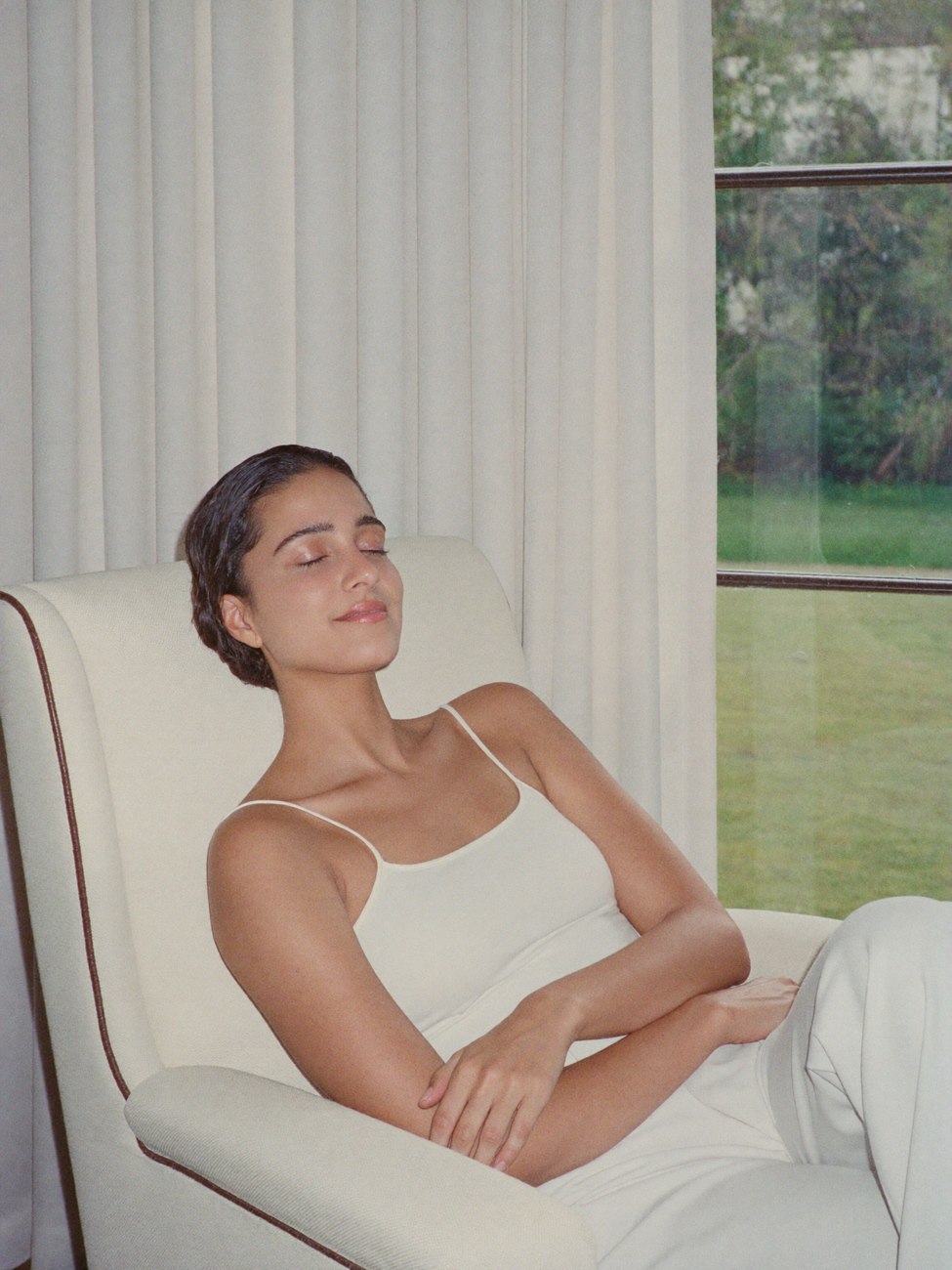 A person resting comfortably beside an open window
